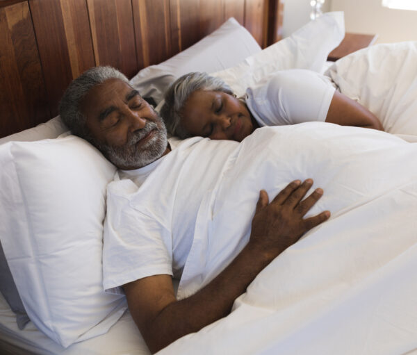 Close-up of a senior African American couple sleeping together in bedroom at home